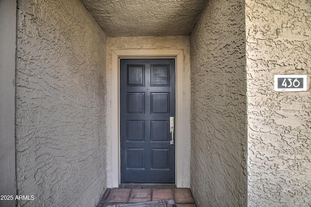 doorway to property featuring stucco siding