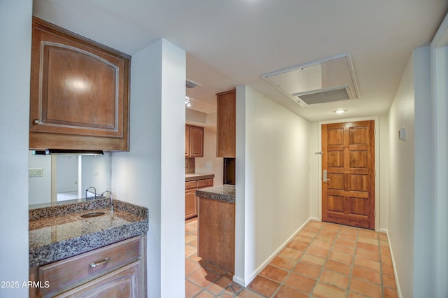 kitchen with light tile patterned floors, visible vents, baseboards, and a sink