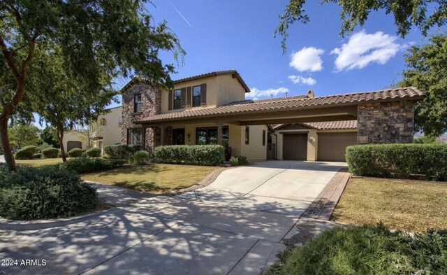 mediterranean / spanish house with a front lawn and a garage