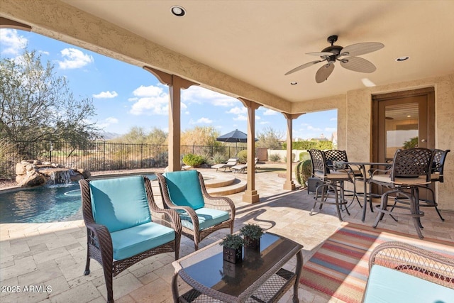 view of patio / terrace featuring a fenced in pool, pool water feature, and ceiling fan