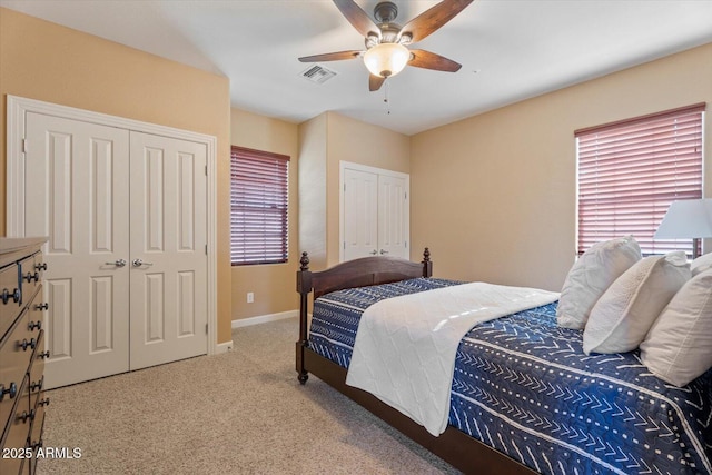 carpeted bedroom with ceiling fan and multiple windows