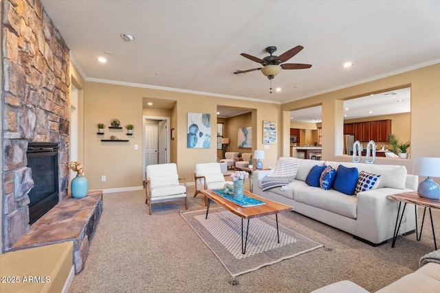 carpeted living room with crown molding, a fireplace, and ceiling fan