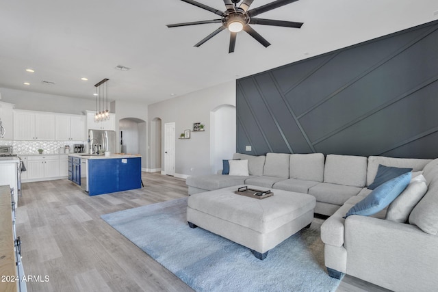 unfurnished living room featuring ceiling fan and light wood-type flooring