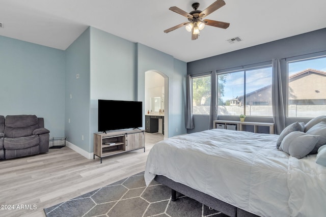 bedroom with ceiling fan, ensuite bath, and light hardwood / wood-style flooring