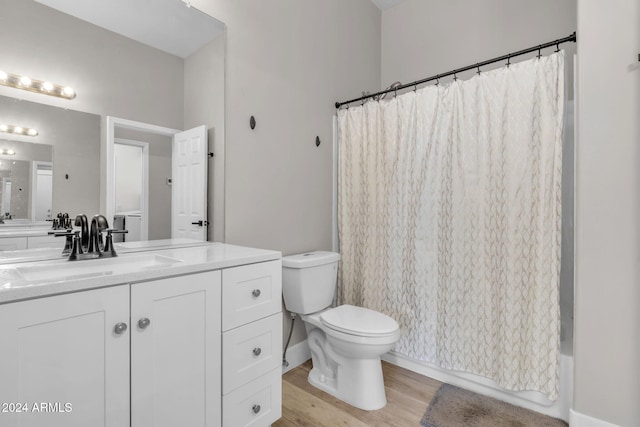 full bathroom featuring hardwood / wood-style floors, vanity, toilet, and shower / tub combo with curtain