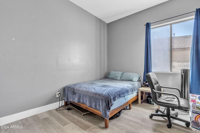 bedroom featuring multiple windows and light hardwood / wood-style floors