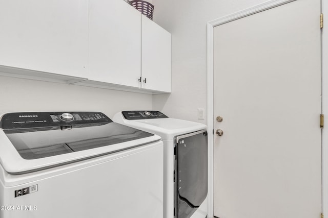 washroom with cabinets and washer and clothes dryer