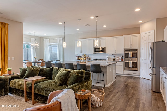 kitchen with light stone counters, dark wood-type flooring, visible vents, open floor plan, and appliances with stainless steel finishes