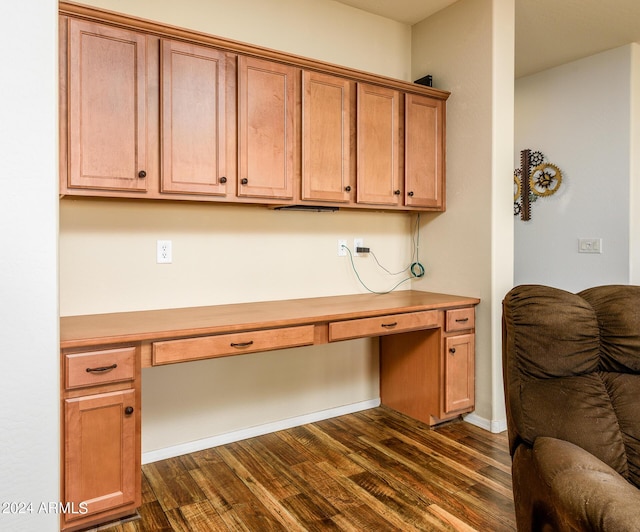 office space with built in desk and dark wood finished floors