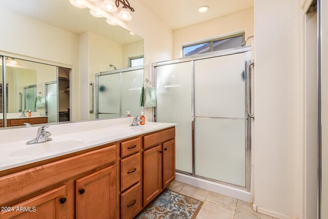 full bathroom featuring a stall shower, double vanity, and a sink