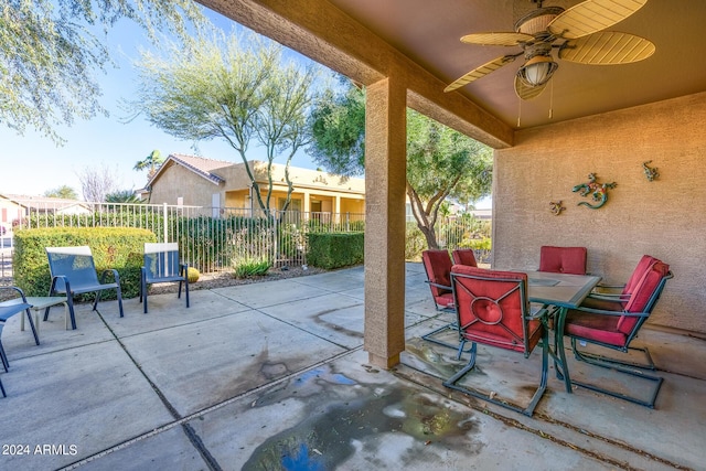 view of patio featuring outdoor dining area, fence, and ceiling fan