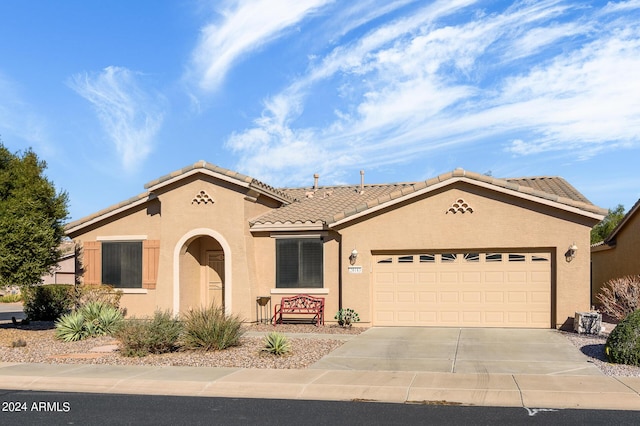 mediterranean / spanish-style house with stucco siding, a garage, and concrete driveway