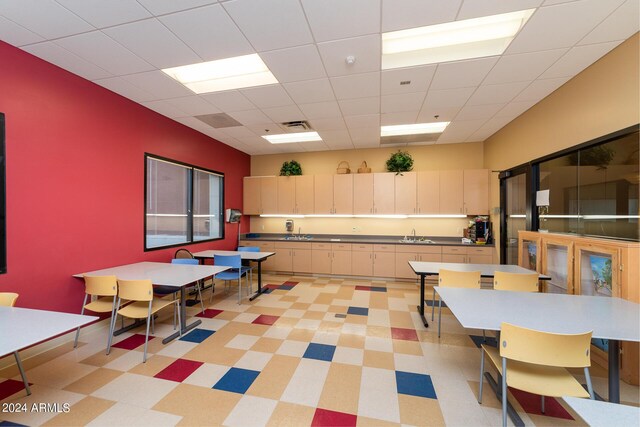 rec room featuring a paneled ceiling, a sink, and visible vents