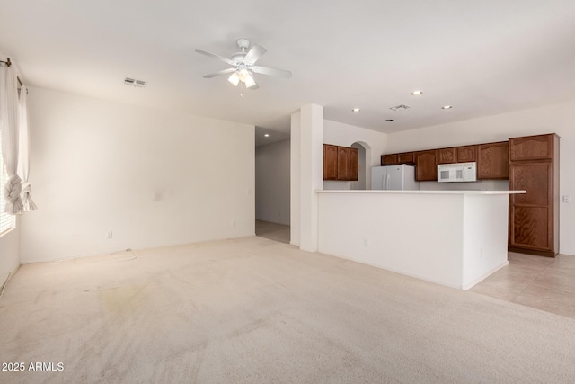 2732 E Tyson St, Chandler, AZ 85225 - unfurnished living room featuring a ceiling fan, recessed lighting, light carpet, and arched walkways