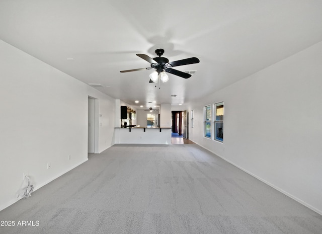 unfurnished living room with light carpet, baseboards, visible vents, and a ceiling fan