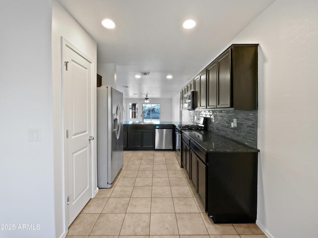 kitchen with visible vents, decorative backsplash, dark stone counters, stainless steel appliances, and light tile patterned flooring