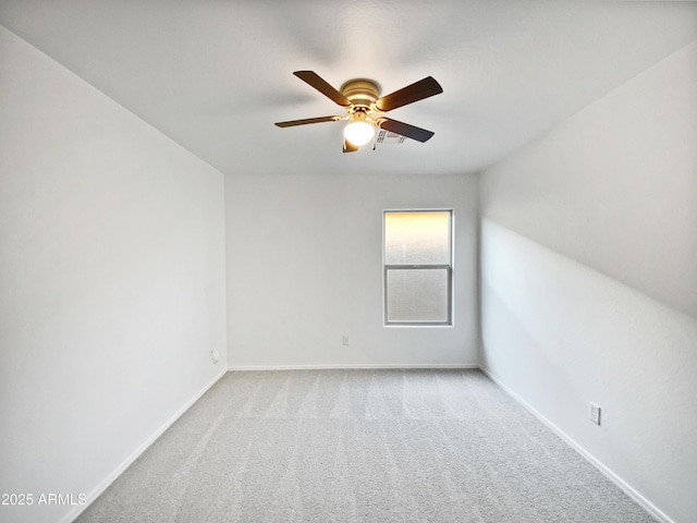 spare room featuring carpet, baseboards, and a ceiling fan