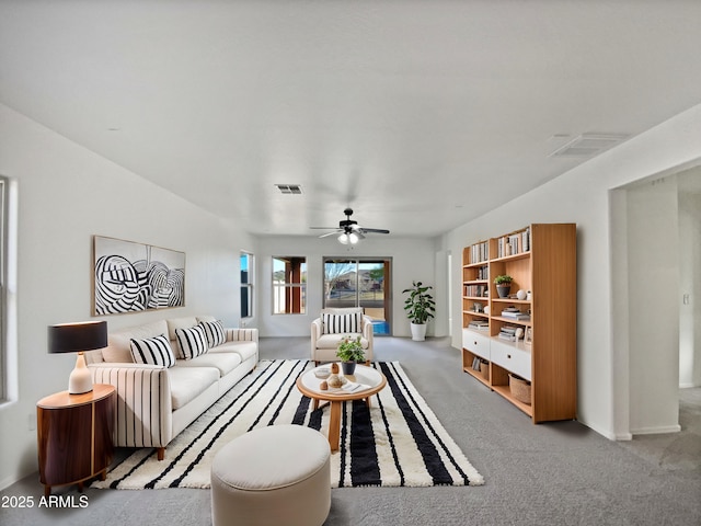 carpeted living area with visible vents and a ceiling fan