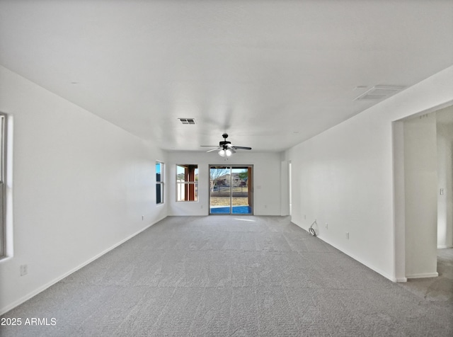 unfurnished living room featuring baseboards, carpet floors, visible vents, and a ceiling fan