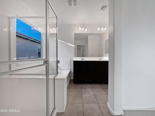 full bathroom with a garden tub, double vanity, visible vents, a sink, and tile patterned floors