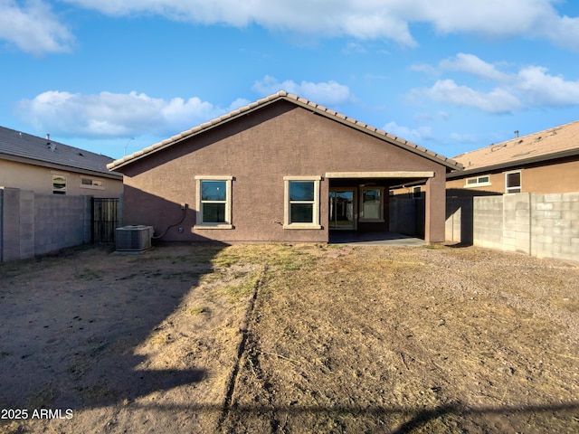 rear view of house with a fenced backyard, a patio area, cooling unit, and stucco siding