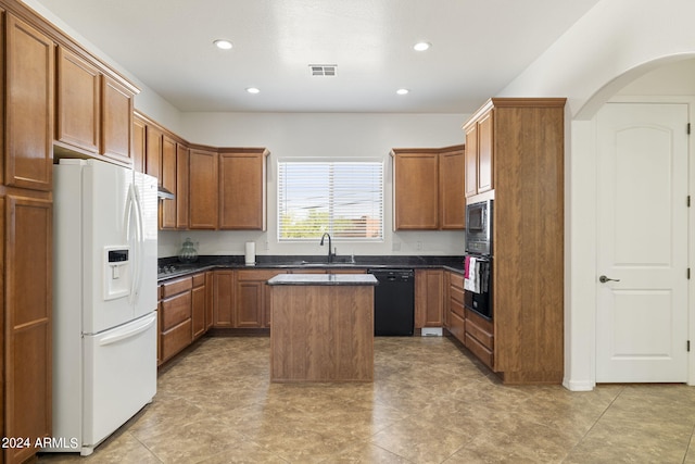 kitchen featuring black appliances, a center island, and sink