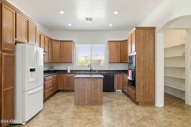 kitchen featuring sink, a kitchen island, and black appliances