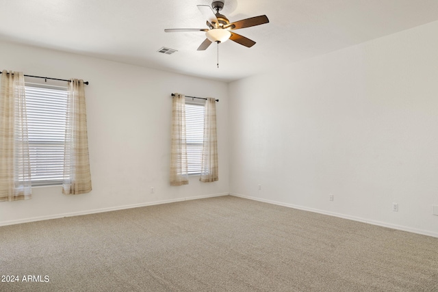 empty room with carpet, a wealth of natural light, and ceiling fan