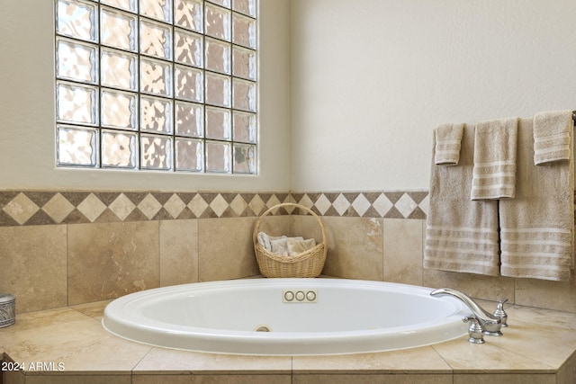 bathroom featuring plenty of natural light and tiled tub