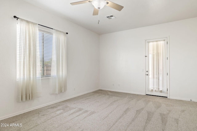 carpeted spare room featuring ceiling fan