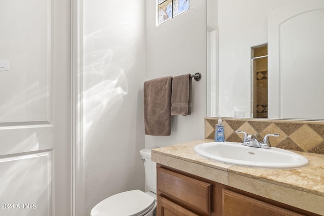 bathroom featuring vanity, toilet, and walk in shower