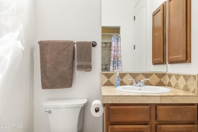 bathroom with vanity, tasteful backsplash, and toilet