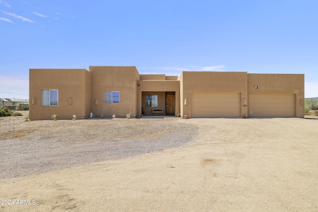 pueblo revival-style home with a garage