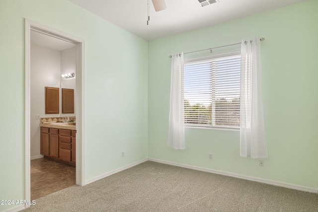 unfurnished bedroom with carpet, ceiling fan, sink, and ensuite bathroom