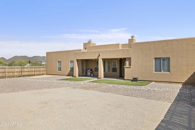 back of property featuring a mountain view and a patio