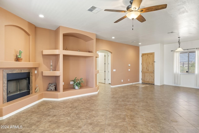 unfurnished living room with ceiling fan and built in features