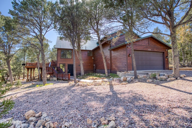 log-style house with a garage and a wooden deck