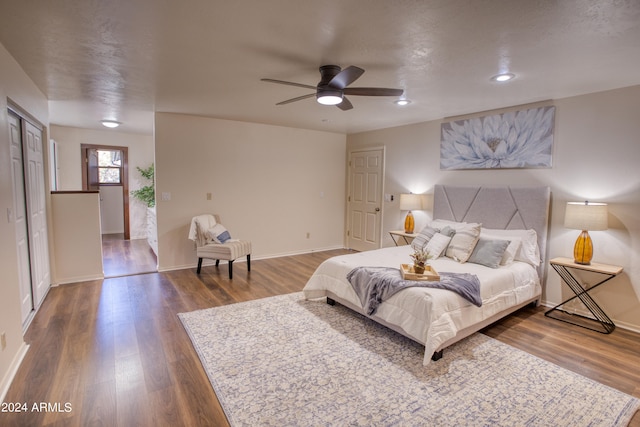 bedroom featuring dark wood-type flooring, a closet, and ceiling fan