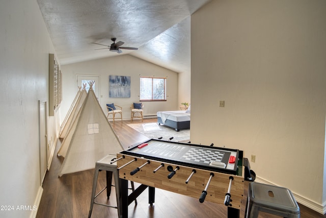 recreation room with vaulted ceiling, hardwood / wood-style flooring, and ceiling fan