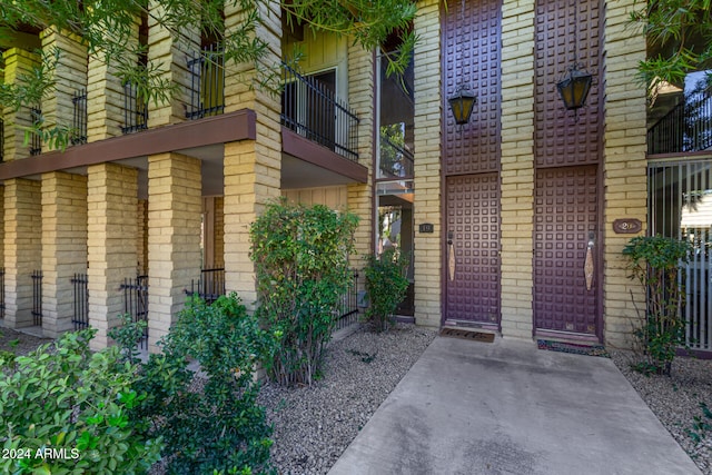 view of exterior entry featuring a balcony