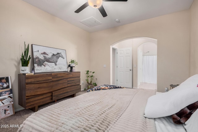 carpeted bedroom with ceiling fan and ensuite bath