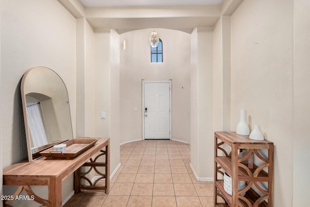 entryway featuring a high ceiling and light tile patterned flooring