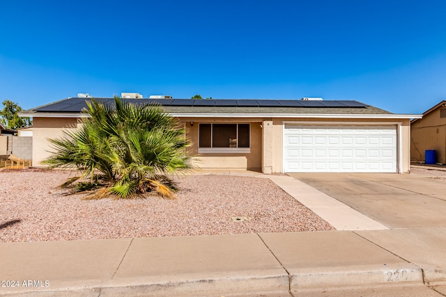 view of front of property featuring solar panels and a garage