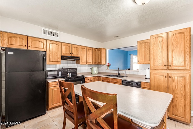 kitchen with a textured ceiling, black appliances, sink, and light tile patterned floors