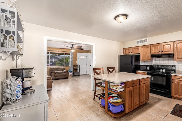 kitchen featuring ceiling fan, black appliances, light tile patterned flooring, and decorative backsplash