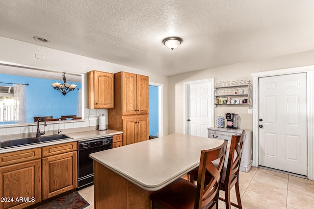 kitchen featuring an inviting chandelier, a textured ceiling, dishwasher, sink, and a center island