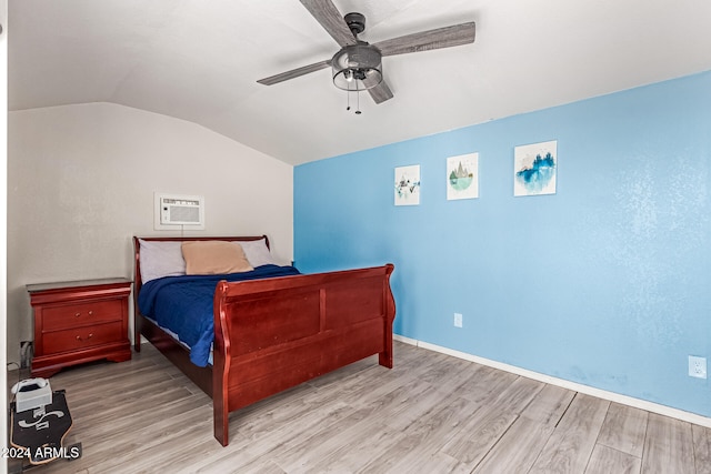 bedroom with vaulted ceiling, a wall mounted AC, light wood-type flooring, and ceiling fan