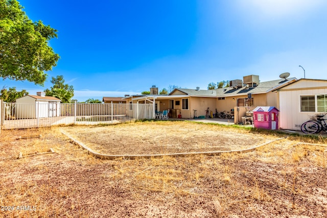 rear view of property featuring a shed and a patio