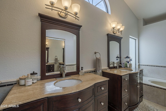 1461 W Tara Dr, Gilbert, AZ 85233 - bathroom with a chandelier, two vanities, a bath, a textured wall, and vaulted ceiling