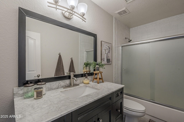 1461 W Tara Dr, Gilbert, AZ 85233 - bathroom featuring a textured wall, vanity, toilet, combined bath / shower with glass door, and a textured ceiling